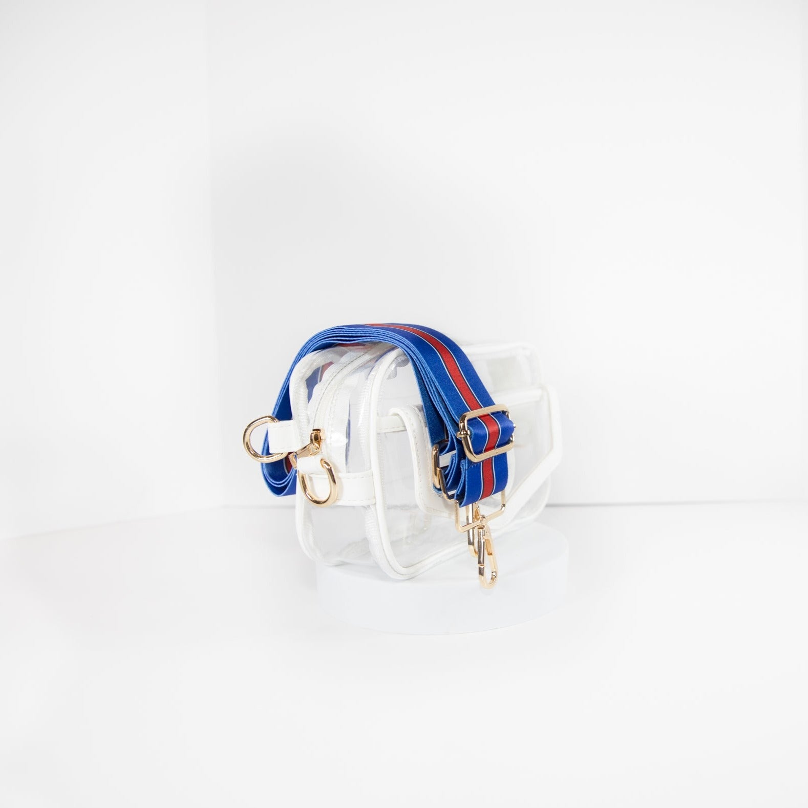 Clear stadium bag with white leather trim, side facing, with a crossbody strap in Buffalo Bills colors.