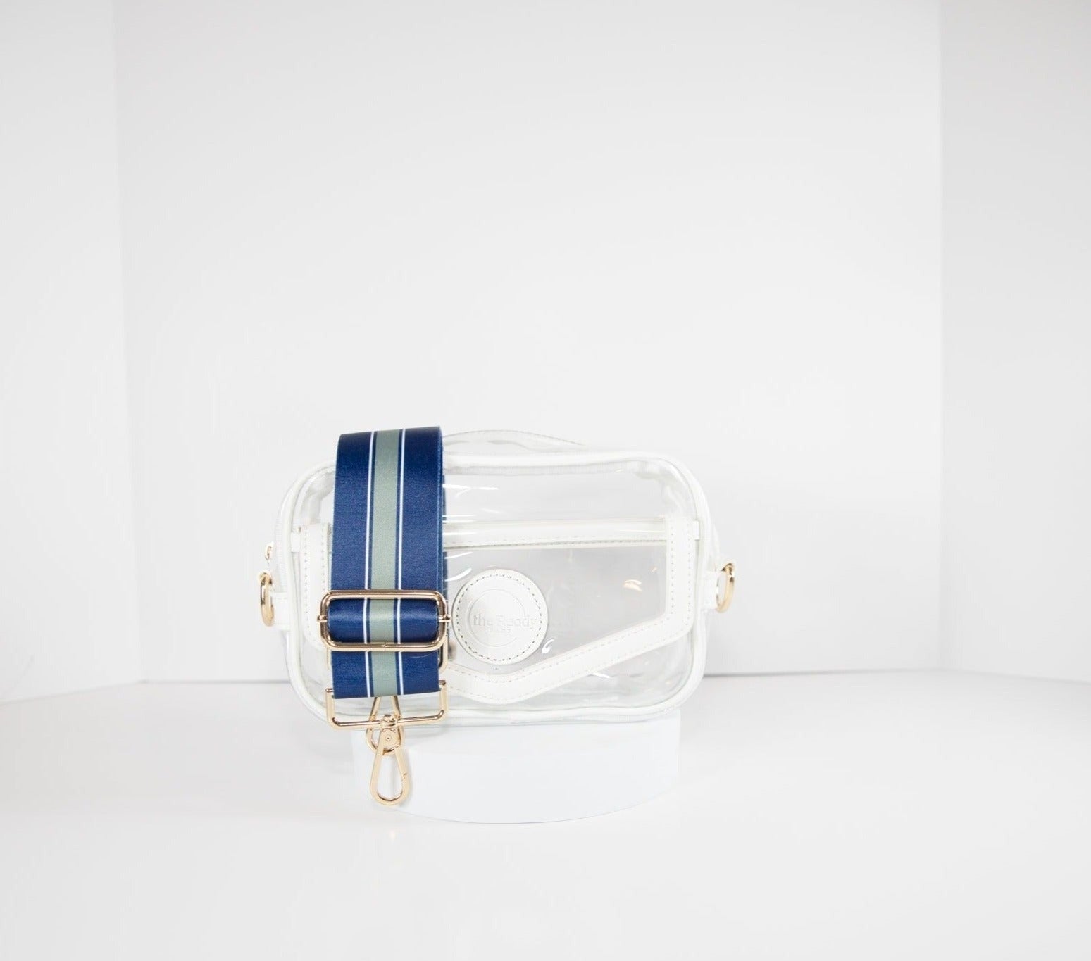 Clear stadium bag in white leather trim, front facing, with a crossbody strap in the team colors of the Dallas Cowboys.