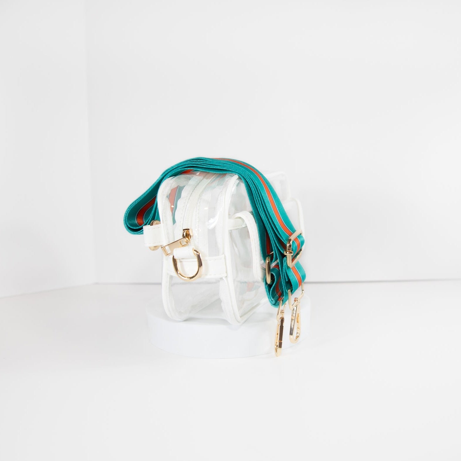 Clear Stadium bag in white leather trim, side facing, with a crossbody strap in Miami Dolphins colors.