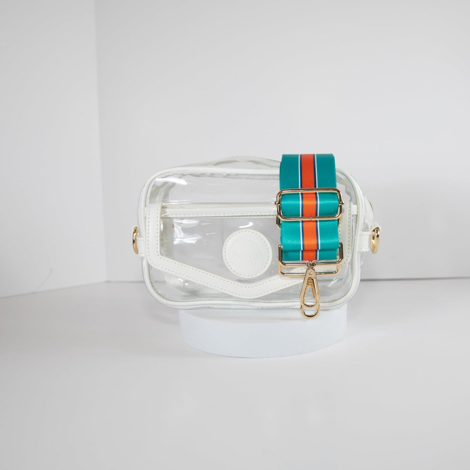 Clear Stadium bag in white leather trim, front facing, with a crossbody strap in Miami Dolphins colors.