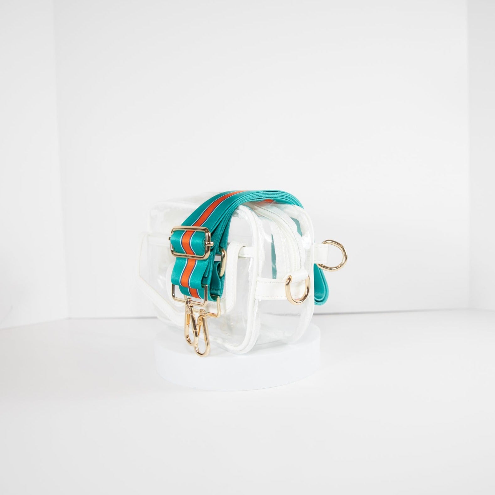 Clear Stadium bag in white leather trim, side facing, with a crossbody strap in Miami Dolphins colors.