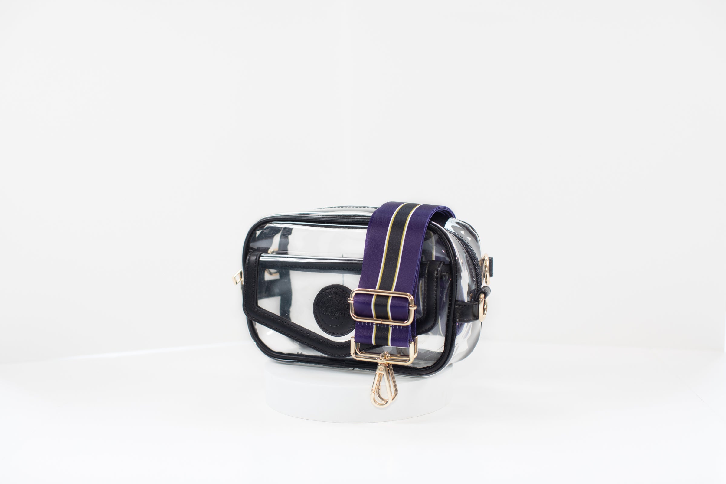 Clear stadium bag with black leather trim, front facing, with a crossbody strap in team colors of the Baltimore Ravens.