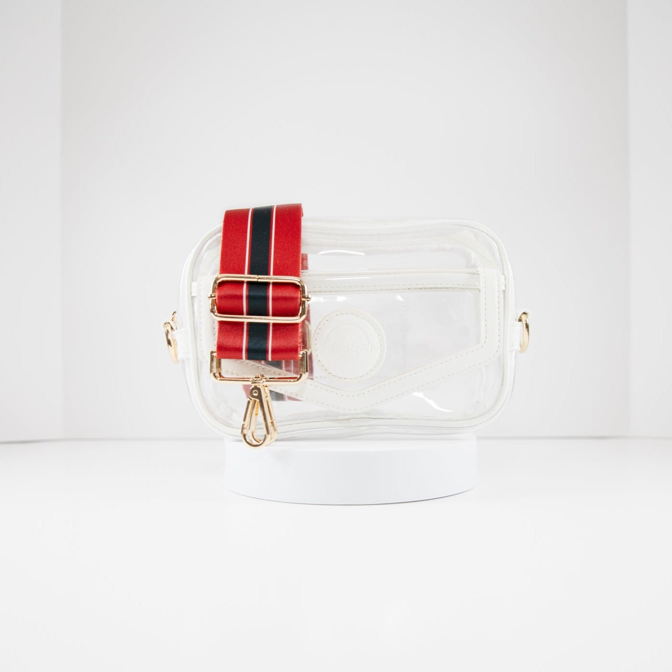 Clear stadium bag with white leather trim, front facing, with a crossbody strap in Houston Texan team colors.